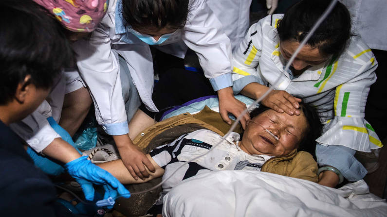 A medical worker treats a woman after an earthquake in Yangbi Yi Autonomous County in southwestern China's Yunnan Province. A pair of strong earthquakes struck China overnight. (PC: Xinhua)